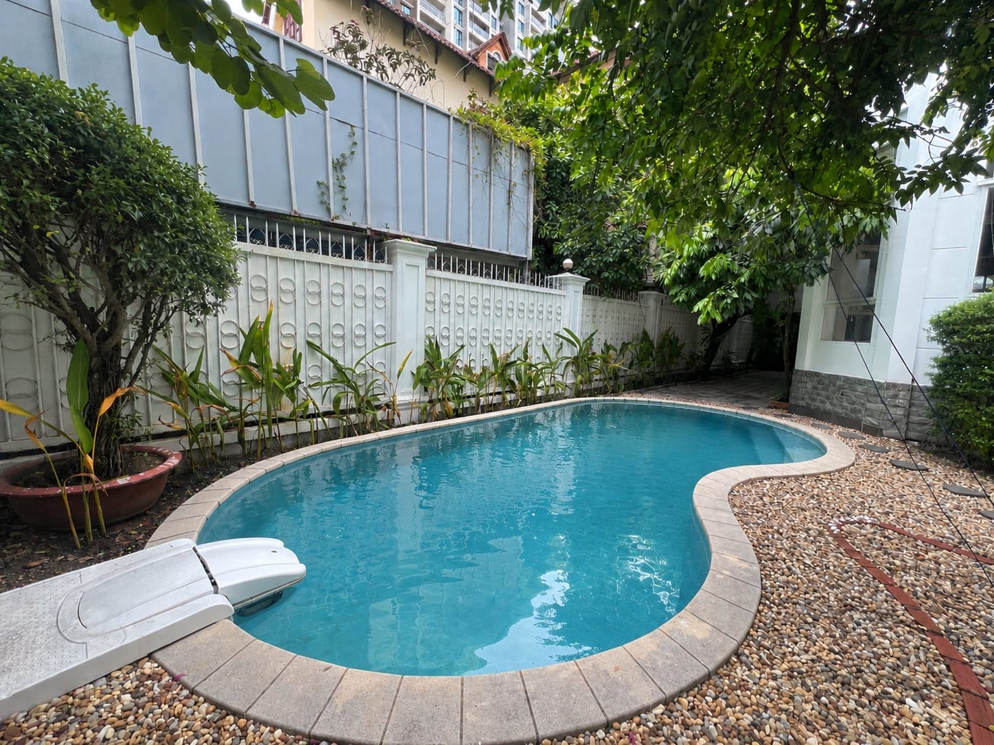 A garden swimming pool beside a villa