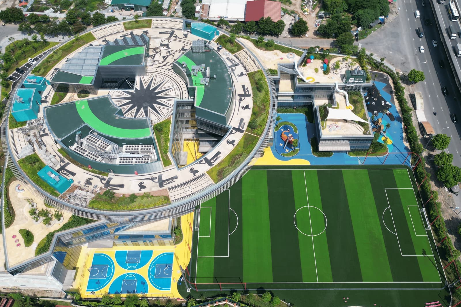 Aerial view of the Dwight School Hanoi campus, with its ring-shaped main building and football pitch