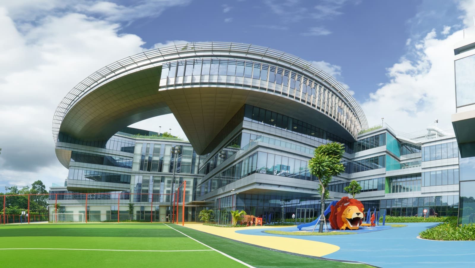 The curved roof of the main building above the pitch and the lion playground