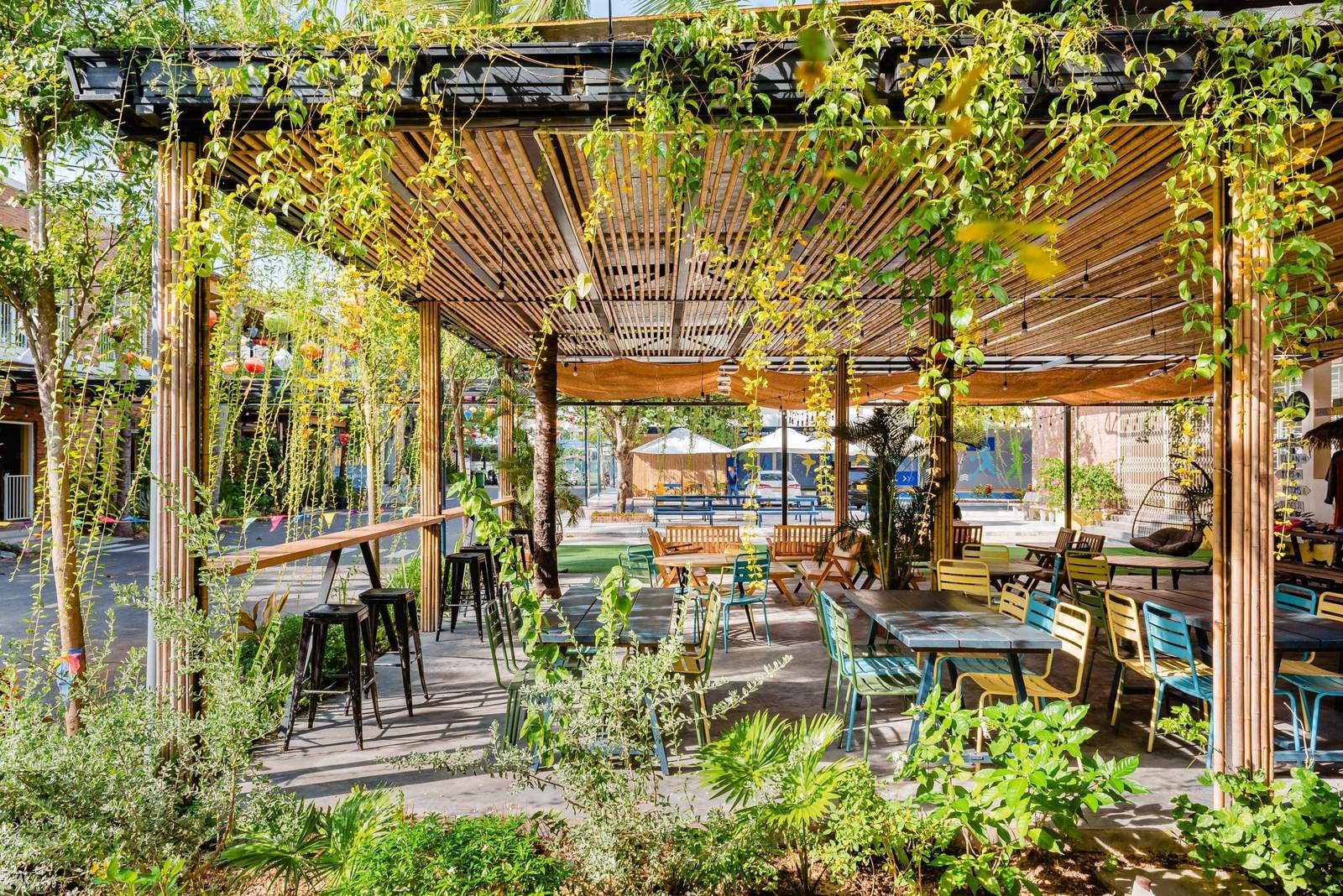 A shaded garden terrace under a vine-covered pergola