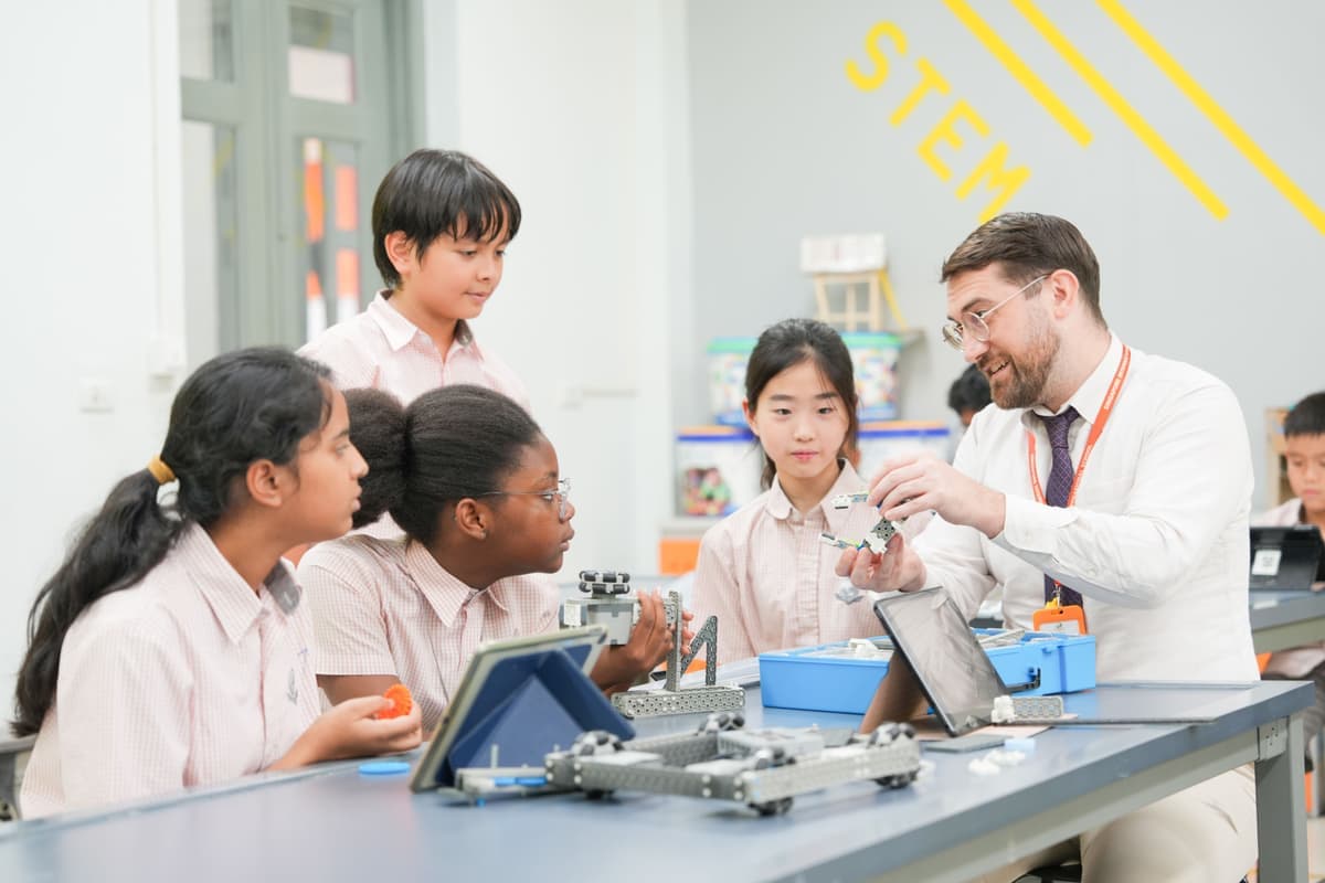 A teacher and students working on a robotics project in a science and technology classroom at Singapore International School
