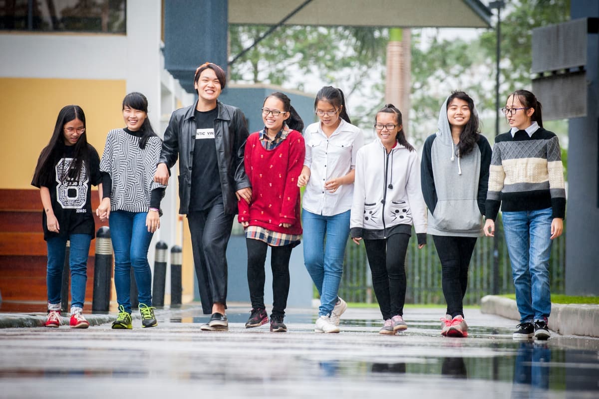 A group of students walking together across the United Nations International School of Hanoi campus
