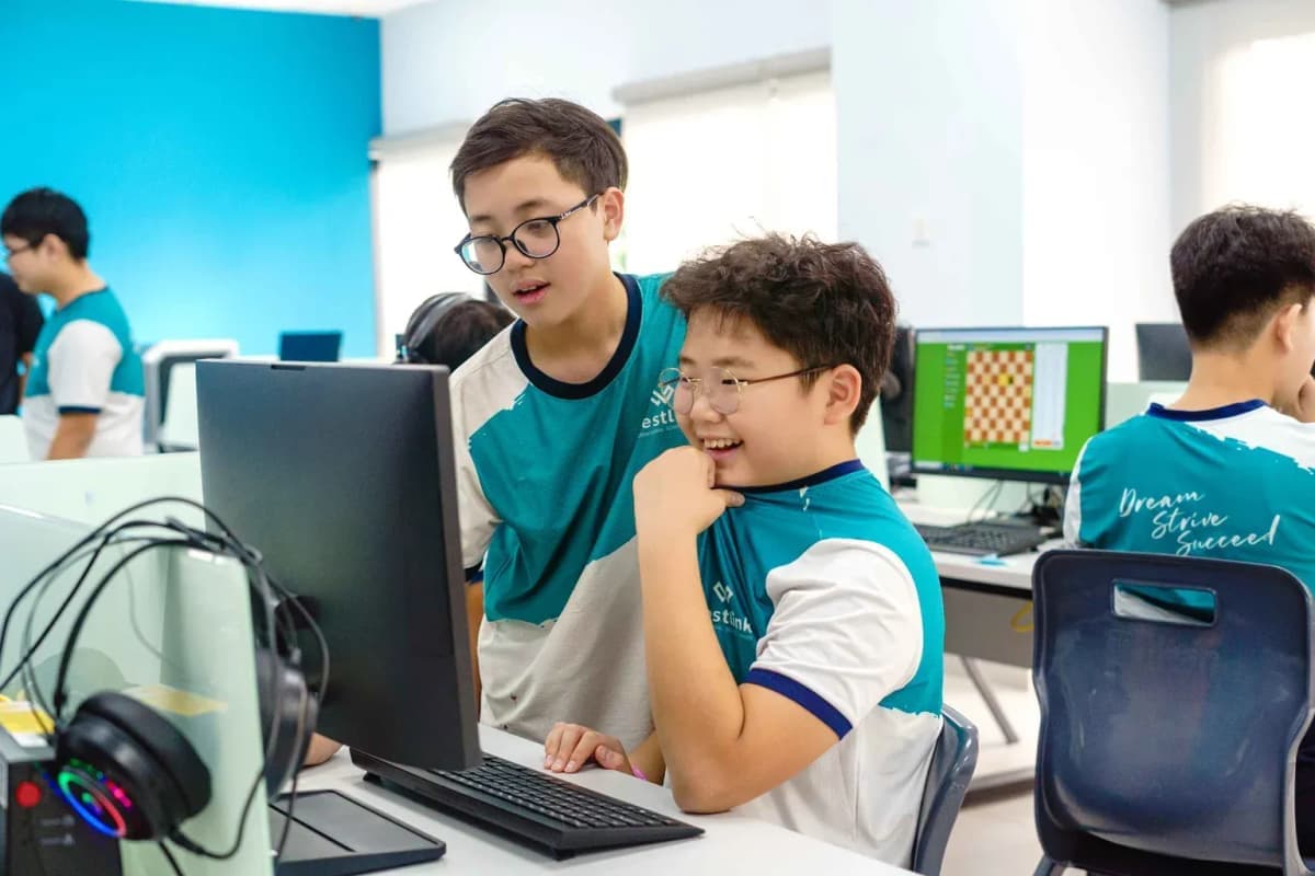 Two students working together at computers in a Westlink International School classroom